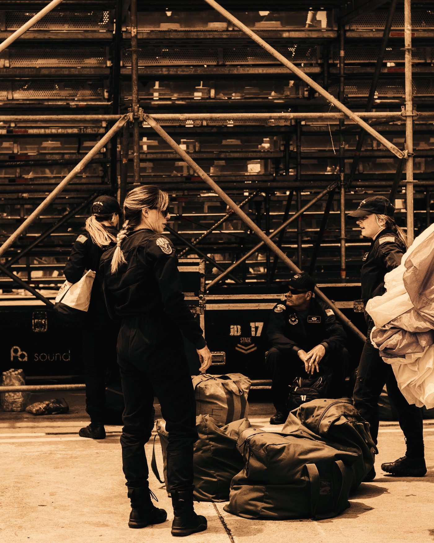 Event crew gathered beneath temporary grandstand scaffolding